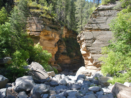 Grey boulders and orange-brown cliffs
