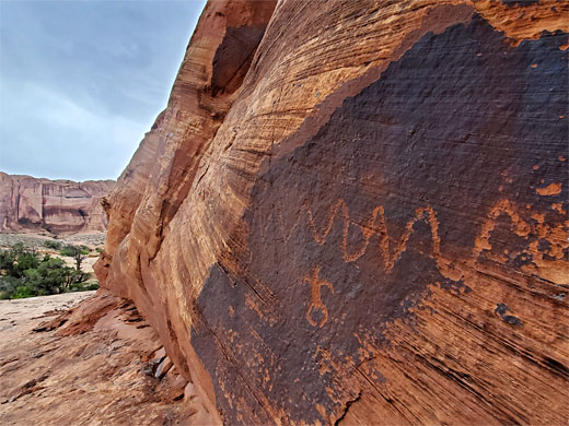 Petroglyphs on dark patina